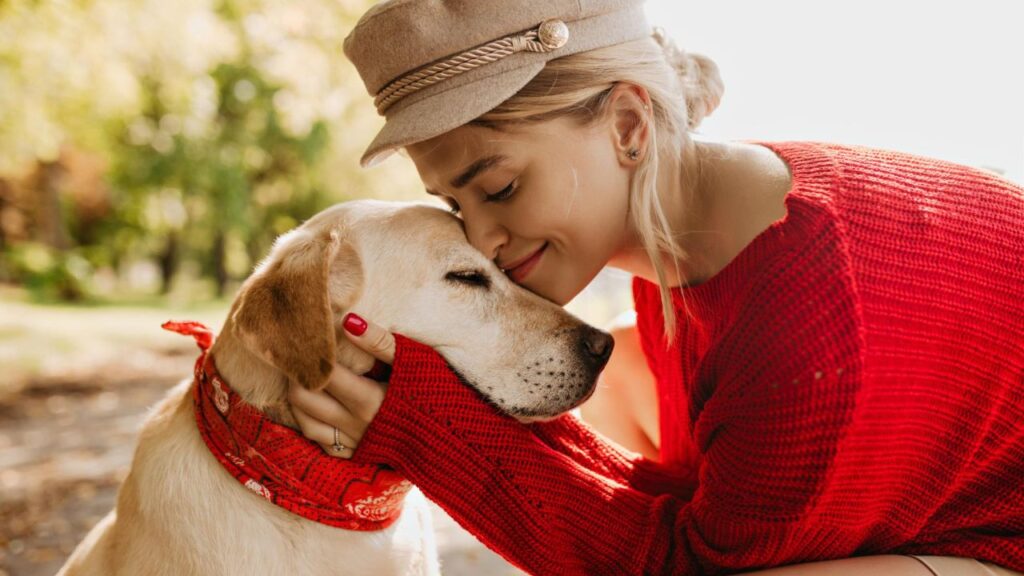 woman loving on her labrador retriever