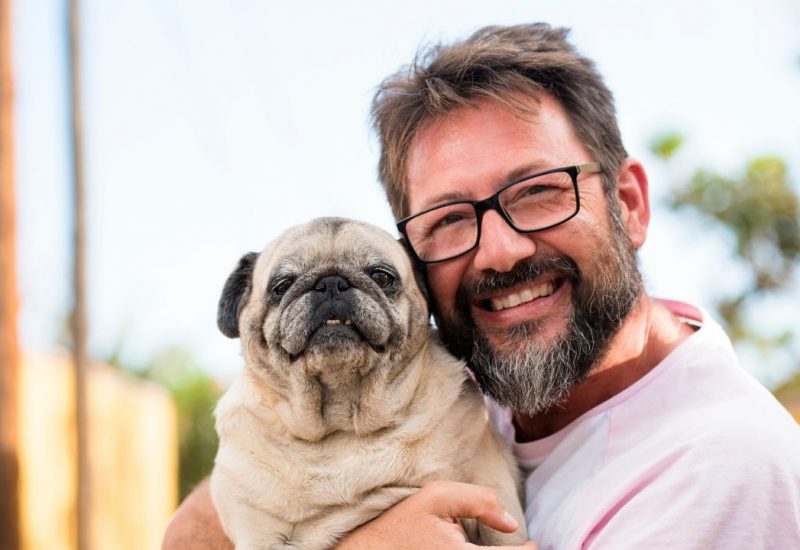 smiling man holding dog smiling man holding dog